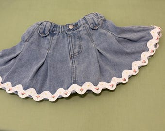 Denim skirt with embroidered flowers on RickRack.