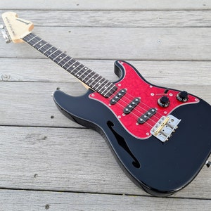 Custom build Exosphere tenor Thinline semi hollow Electric Ukulele. Handmade with triple pickups and a working tremolo! Padded gig bag incl.