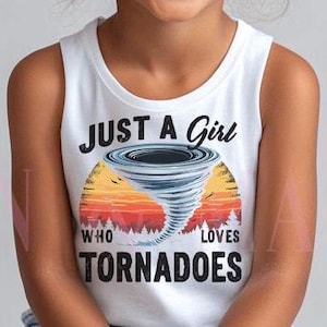 Puede incluir: Una niña pequeña con un top blanco sin mangas que dice "Just a girl who loves tornadoes" y un gráfico de un tornado. Lleva pantalones cortos de mezclilla y tiene el pelo en dos moños.