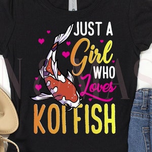 May include: A black short-sleeve t-shirt featuring a graphic of a koi fish with pink hearts and the text "JUST A GIRL WHO LOVES KOI FISH" in yellow and pink, paired with a pair of gold metallic sandals and blue denim shorts with distressed details.