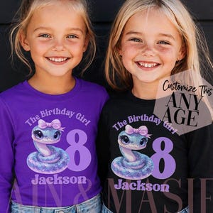 Könnte beinhalten: Ein lila Langarmshirt und ein schwarzes Langarmshirt, jeweils mit einer Grafik einer glitzernden blauen Schlange mit rosa Schleife, dem Text The Birthday Girl, der Zahl 8, dem Namen Jackson und einem Etikett mit Customize This ANY AGE.