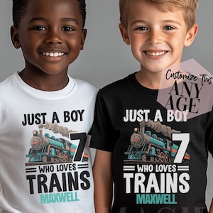 May include: Two children wearing matching t-shirts. The white shirt has a train graphic with the text "JUST A BOY WHO LOVES TRAINS 7 MAXWELL". The black shirt has the same design. The shirts are for a child's birthday.