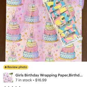 The image is a review photo of a girls birthday wrapping paper, Birthd.... 7 in stock priced at $16.99. The wrapping paper is described as a perfect touch for a birthday present, and the seller's note mentions that the gift packaging was a black box, which was prepared to have enough wrapping paper to cover the gift. The seller's rating of 5 stars indicates that the product is highly recommended.