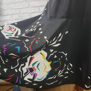May include: Black maxi skirt with a colorful abstract print. The print features white, yellow, red, blue, and purple shapes.