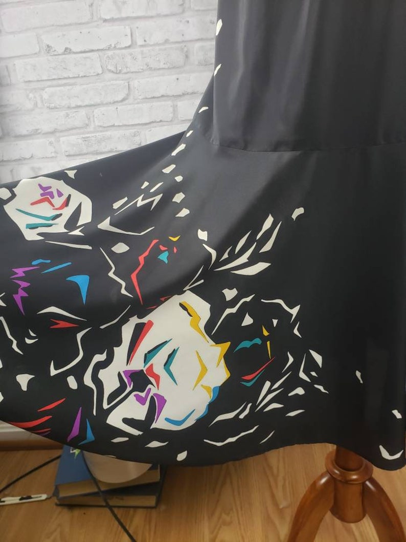 May include: Black maxi skirt with a colorful abstract print. The print features white, yellow, red, blue, and purple shapes.