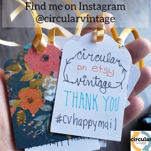 May include: A set of white gift tags with a handwritten message that says "circular on etsy vintage" and "thank you #cvhappymail". The tags are tied with yellow ribbon and have a floral design.