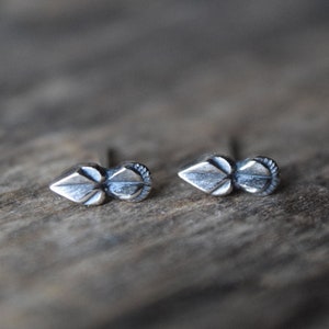 May include: A pair of silver stud earrings with a leaf design.