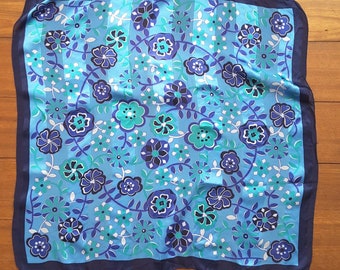 Zijde sjaal, made in Italy, met bloemen en een glanzende streep waardoor een mooi vleug, glinstering in het stof ontstaat.