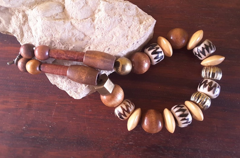 Wooden beaded necklace with gold colored beads in natural shades.