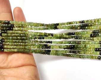 May include: A strand of green and black gemstone beads. The beads are faceted and have a slightly irregular shape. The strand is approximately 16 inches long.