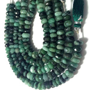 May include: A strand of emerald green gemstone beads, faceted and polished, with a dark green tassel at the end.
