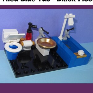 以下が含まれることがあります： カラフルなブロックで作られた2つのミニチュアバスルームシーン。1つのシーンは黒いベース、もう1つは白いベースです。各シーンには、青い浴槽、トイレ、シンク、その他のバスルームの備品が含まれています。