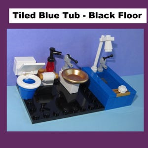 May include: A miniature bathroom scene constructed from colorful building blocks. The set includes a blue bathtub, a toilet, a sink with a golden basin, and various faucets. The scene is set on a black base with a purple background.