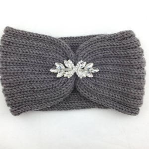 May include: Gray knitted headband with a large, clear rhinestone embellishment in the center.