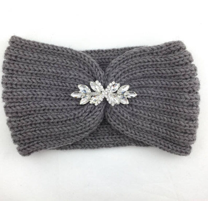 May include: Gray knitted headband with a large, clear rhinestone embellishment in the center.