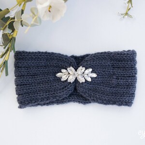 May include: A dark blue knitted headband with a silver rhinestone embellishment in the center.