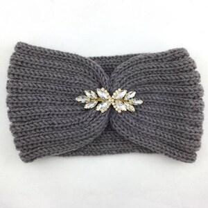 May include: Gray knitted headband with a gold and clear rhinestone embellishment.