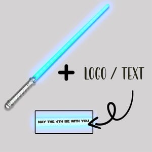 May include: A glowing cyan light sabre with a silver metallic handle featuring a textured grip. Next to the sabre is a plus sign and the text LOGO / TEXT. Below, a rectangular box displays the text MAY THE 4TH BE WITH YOU with an arrow.