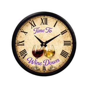 May include: Round wall clock with a black frame and a textured, beige face. The clock features Roman numerals, black hands, and the words "Time To Wine Down" in purple script. Two wine glasses are depicted.