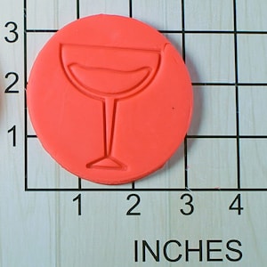 May include: A red round silicone cookie cutter with a wine glass design. The cookie cutter is 2 inches in diameter.