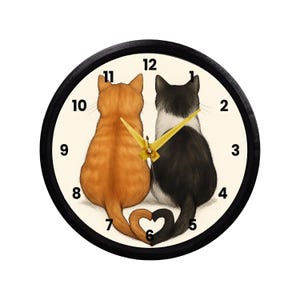 May include: A round wall clock with a black frame. The clock face features two cats, one orange and one black and white, sitting together with their tails forming a heart shape. Gold clock hands point to the time.