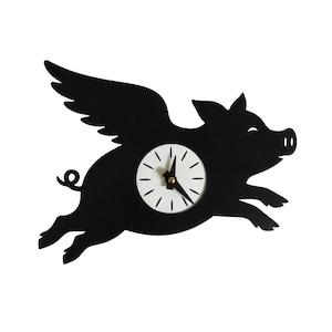 May include: A black wall clock shaped like a flying pig with wings. The clock face is white with black markings and gold hands. The pig is in mid-flight, with its legs extended. The clock is a whimsical decorative item.