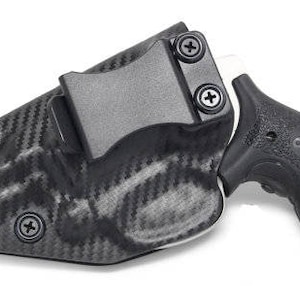 May include: A black and gray carbon fiber holster with a black handgun. The holster has a clip for attaching to a belt. The handgun has a textured grip.