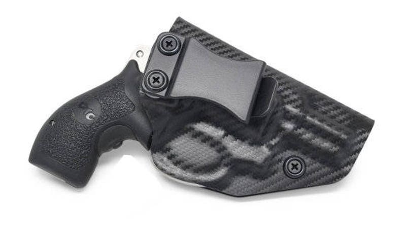 May include: Black handgun in a black and gray patterned holster. The holster has a belt clip and is secured with screws. The handgun grip has a textured surface for a secure hold.