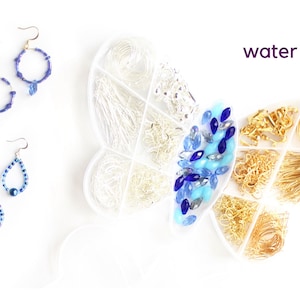 May include: An overhead shot displays jewelry-making supplies and finished earrings. A butterfly-shaped container holds silver and gold findings, blue and clear beads. Two pairs of blue beaded earrings are also shown. The word "water" is written in purple.