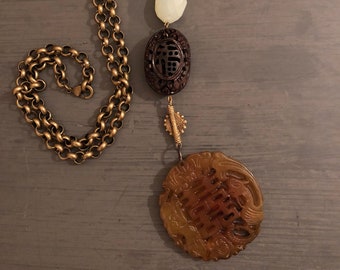Amber Chinese Motif hand carved with stones and carved wood beads on 18+ inch bronze chain link necklace.