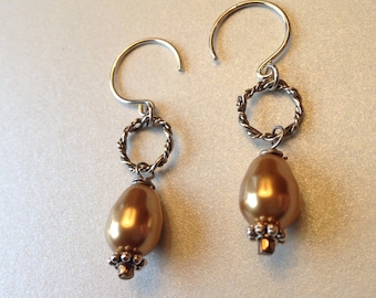 Silver earrings on circular ear wire with a golden Swarovski pearl drop