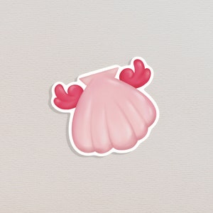 以下が含まれることがあります： ピンクの貝殻に赤い腕が2本ついた、漫画のキャラクターのようなデザインです。