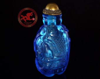 Antique Chinese Snuff Bottle Carved in blue Glass with Elephant, base in the shape of elephant legs and polished copper stopper