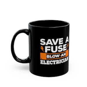 May include: Black ceramic coffee mug with the text "SAVE A FUSE BLOW AN ELECTRICIAN" in white and orange. The mug has a curved handle and a glossy finish. The design includes a lightning bolt graphic.