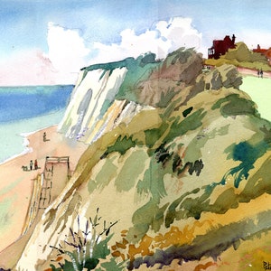Puede incluir: Una pintura de acuarela de un acantilado blanco que domina una playa de arena con agua azul. El acantilado está cubierto de vegetación verde y hay casas en la cima del acantilado. La pintura está firmada "Peter Day".