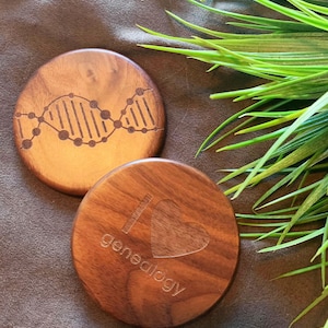 May include: Two wooden coasters with laser engraved designs. One coaster features a DNA double helix and the other has a heart with the text "I love genealogy".