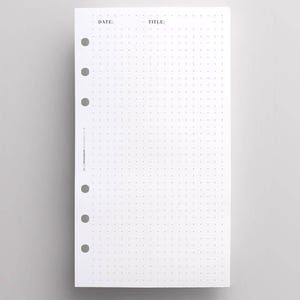 Peut inclure: Une page de recharge d'agenda rectangulaire blanche avec un motif à points. La partie supérieure comporte le texte imprimé DATE : et TITLE :. La marge gauche contient six trous perforés circulaires et le texte vertical CROSSBOW PLANNER.
