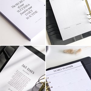 May include: A black leather binder planner with gold rings containing white paper inserts. The pages feature printed text including The Secret of your Success is found in your Daily Routine, Week 52, 365 Days, and Yearly Planner with a gold pen.