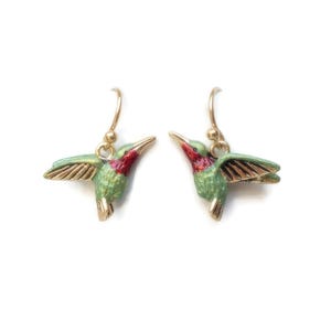 May include: A pair of gold hummingbird earrings with green and red enamel. The hummingbirds are in flight with their wings spread.