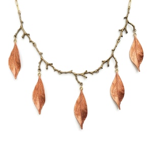 May include: A copper leaf necklace with a delicate branch design. The necklace features five copper leaves hanging from the branches.