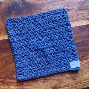 May include: A blue crocheted dishcloth with a white tag that says "Handmade with Love".