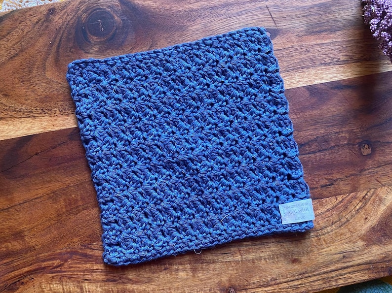 May include: A blue crocheted dishcloth with a white tag that says "Handmade with Love".