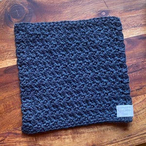 May include: A dark blue crocheted dishcloth with a white tag that says "Handmade with Love".