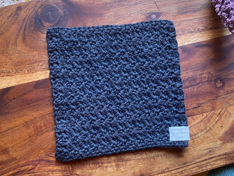 May include: A dark blue crocheted dishcloth with a white tag that says "Handmade with Love".