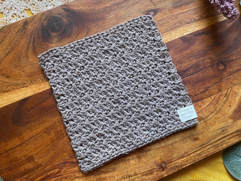 May include: A gray crocheted dishcloth with a white tag that says "Handmade in South Africa".