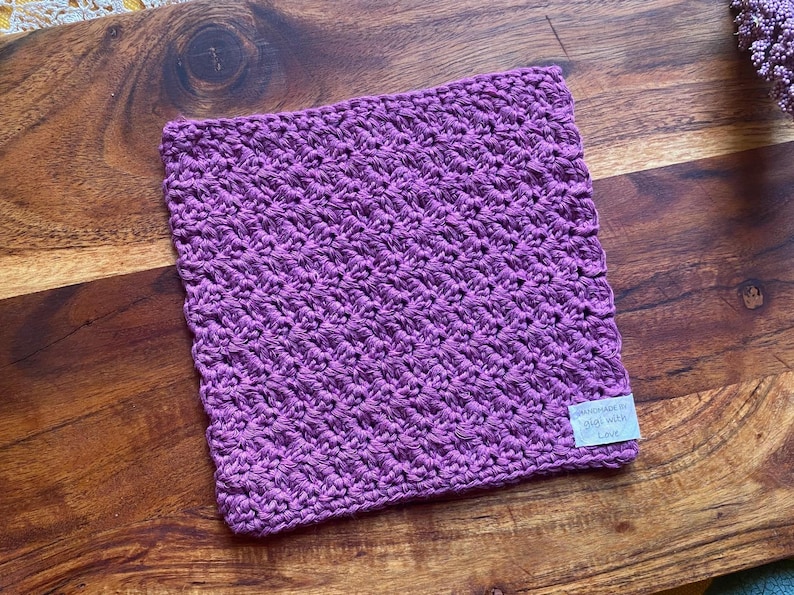 May include: Purple crocheted dishcloth with a white tag that says "Handmade with Love".