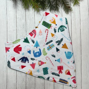 May include: White cotton bandana with a Christmas-themed print featuring gnomes, candy canes, presents, and snowflakes.