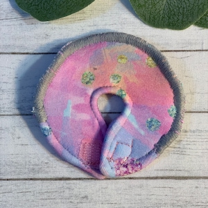 Peut inclure: Un collier pour chien en tissu tie-dye rose et bleu avec une bordure grise et une fermeture velcro.