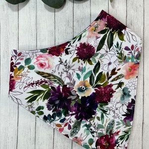 May include: A white bandana with a floral print featuring burgundy, purple, and green watercolor flowers.