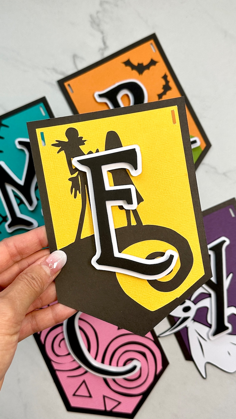 Puede incluir: Un banner de Halloween con las letras "MERRY" en negro con contornos blancos. Cada letra est&aacute; sobre un fondo de color diferente. La "M" est&aacute; sobre turquesa, la "E" est&aacute; sobre amarillo, la "R" est&aacute; sobre naranja y la "Y" est&aacute; sobre morado. Cada letra tiene una silueta de personaje de Halloween diferente.